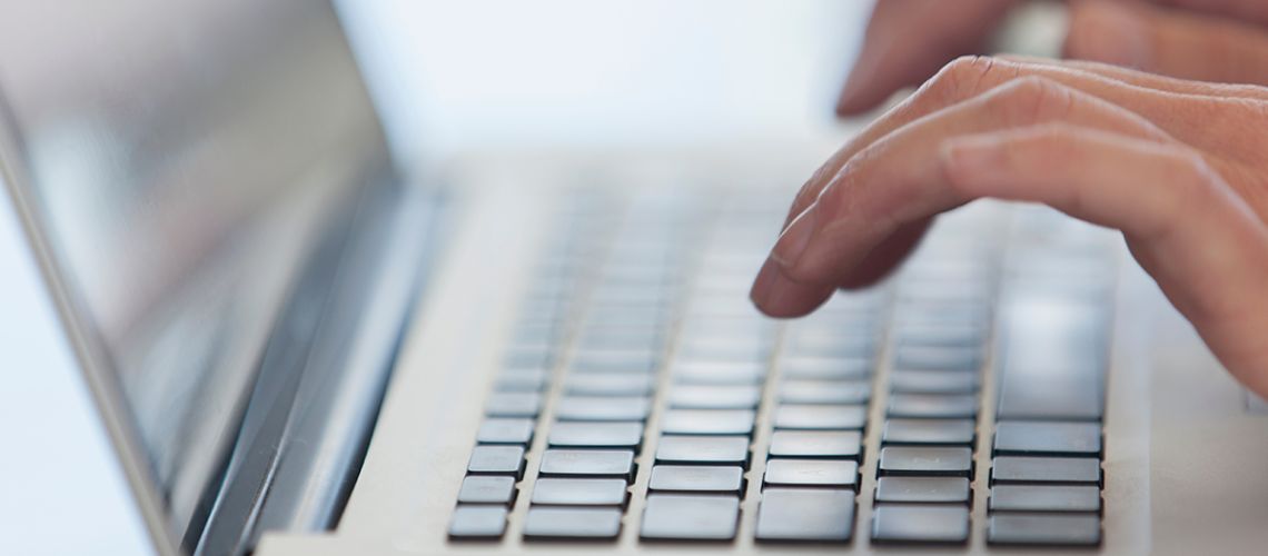 Close up hands typing on laptop
