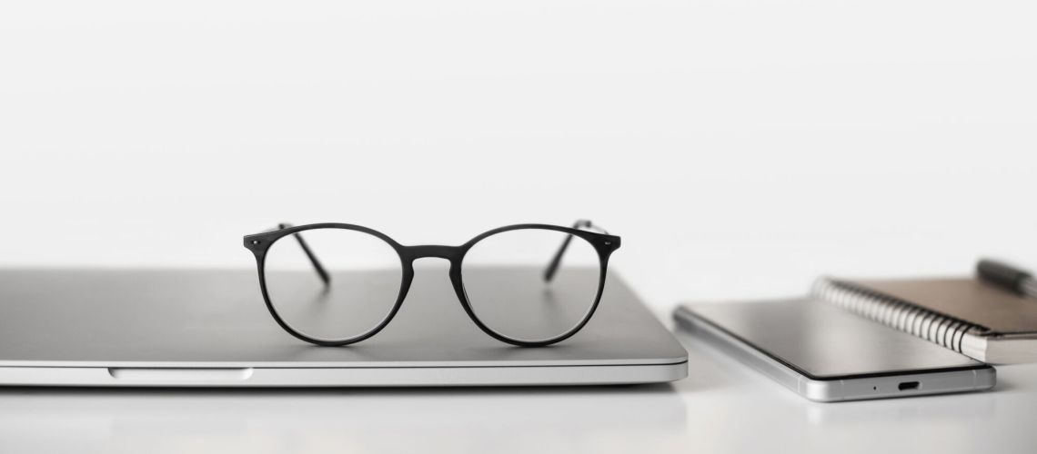 Workplace - laptop computer, smartphone and eyeglasses at office